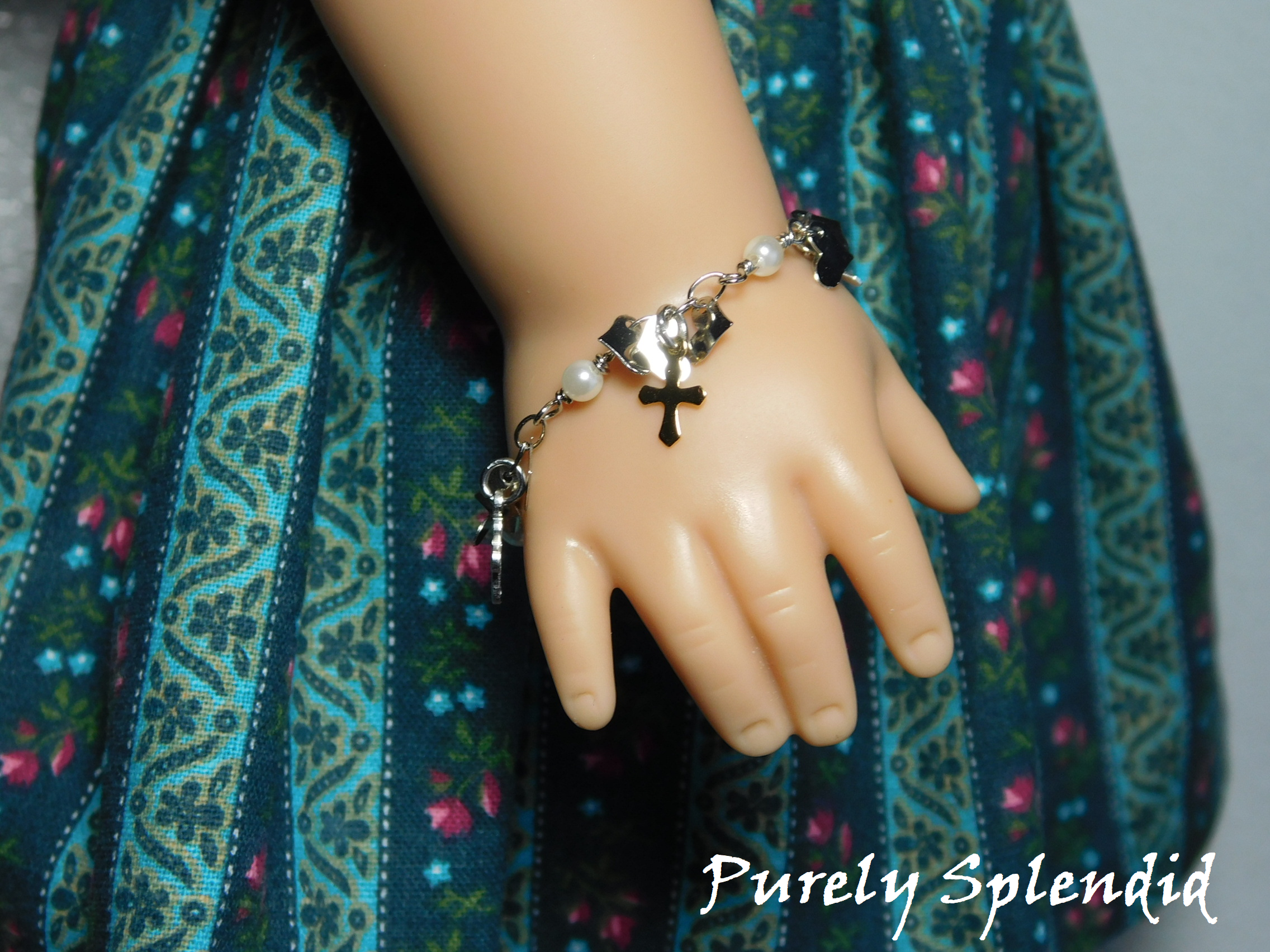 18 inch doll shown wearing a Cross Chrm Bracelet with tiny hearts and gold and silver colored crosses