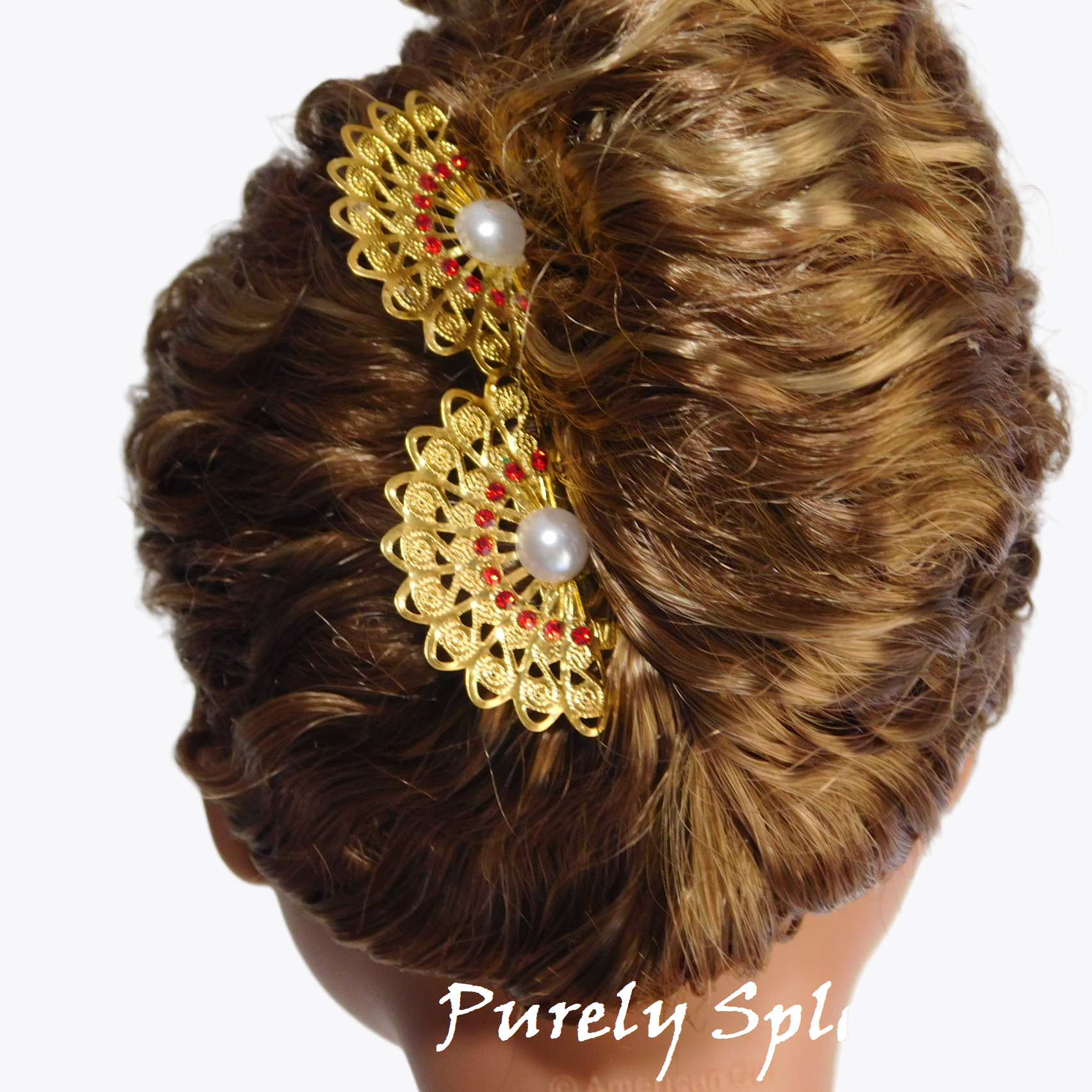 set of two gold filigree fans with red rhinestones and a pearl center shown in an 18 inch dolls updo