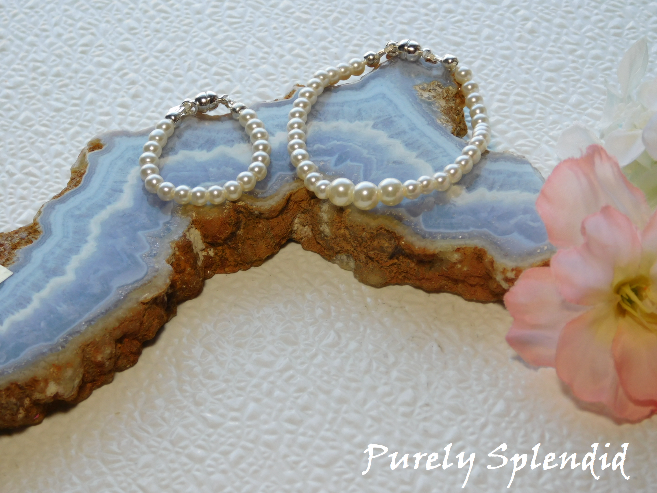 White Pearl Bracelet and Graduated White Pearl Necklace for 18 inch dolls displayed on a colorful piece of rock