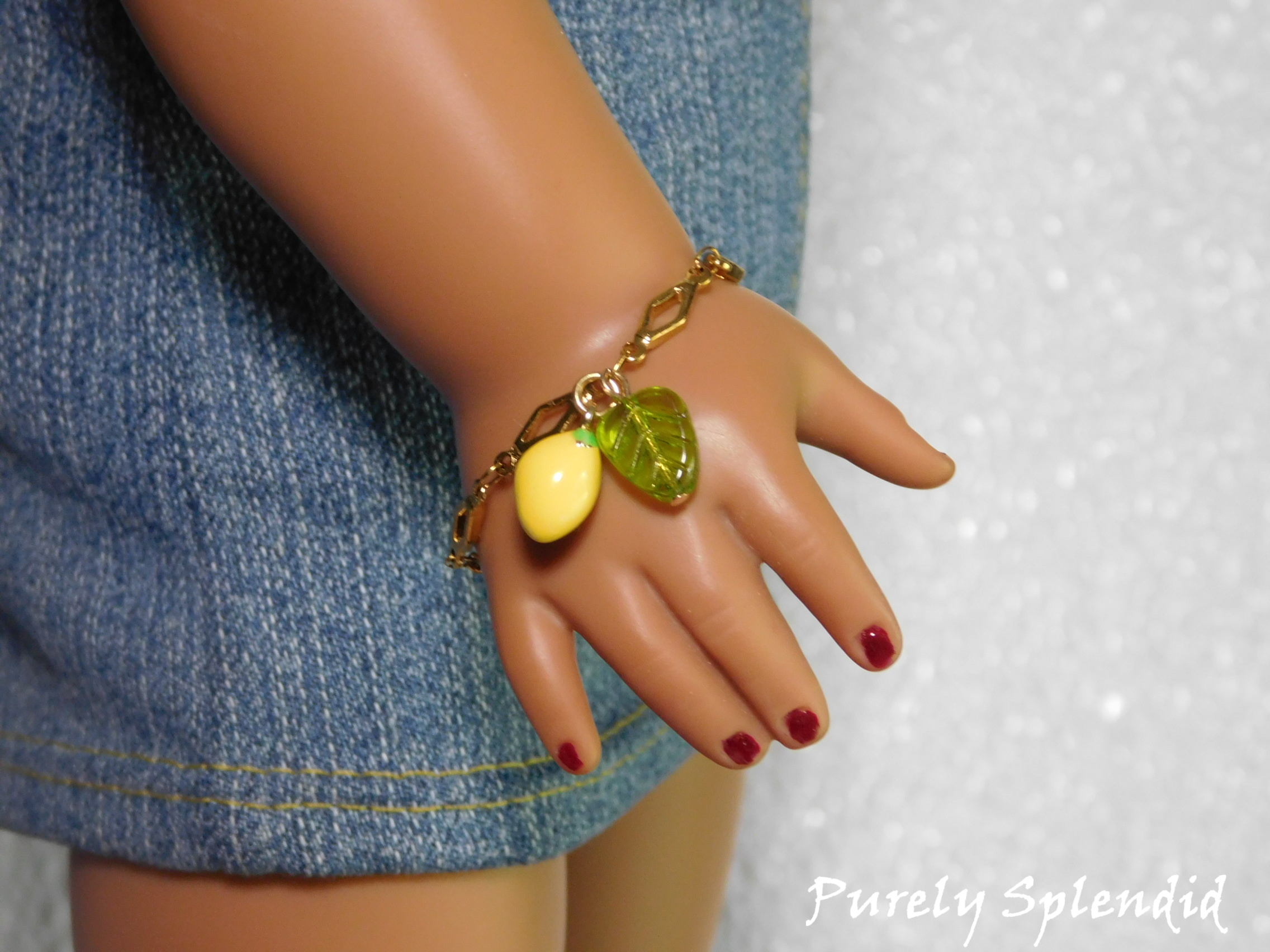 18 inch doll wearing a decorative chain with lemon and leaf hanging from it