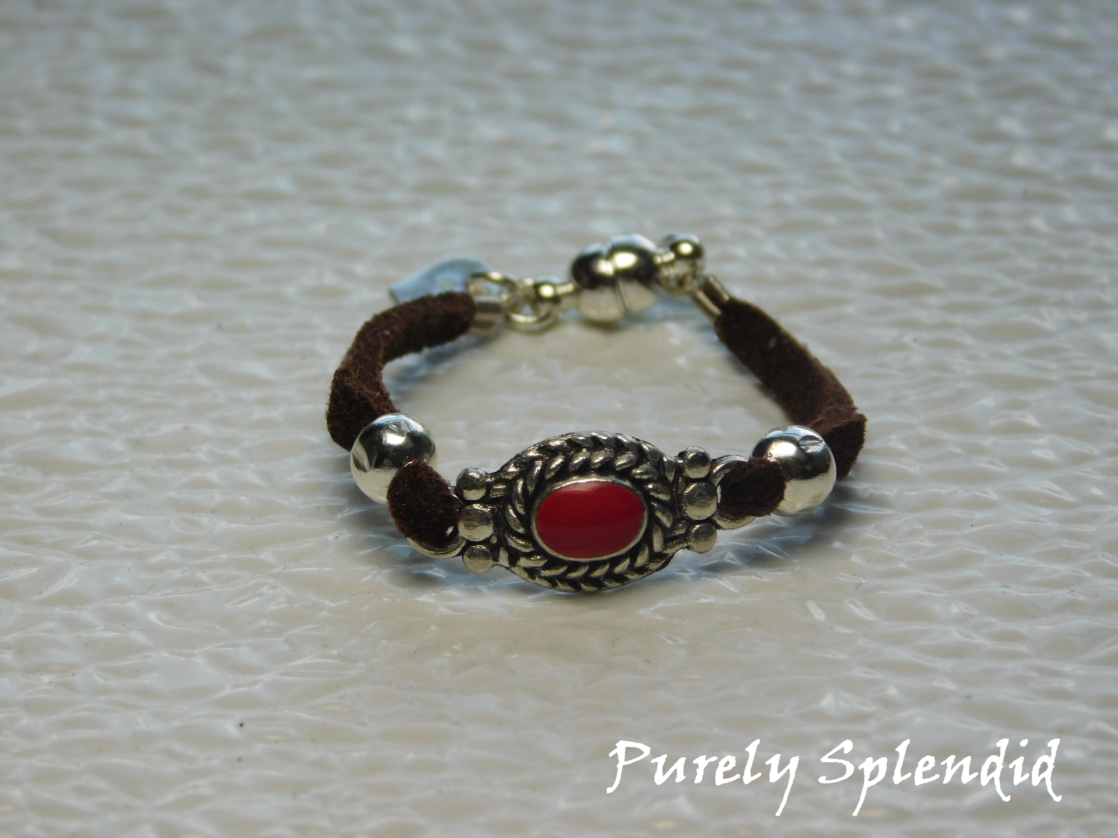 Brown suede bracelet with silver and red focal point