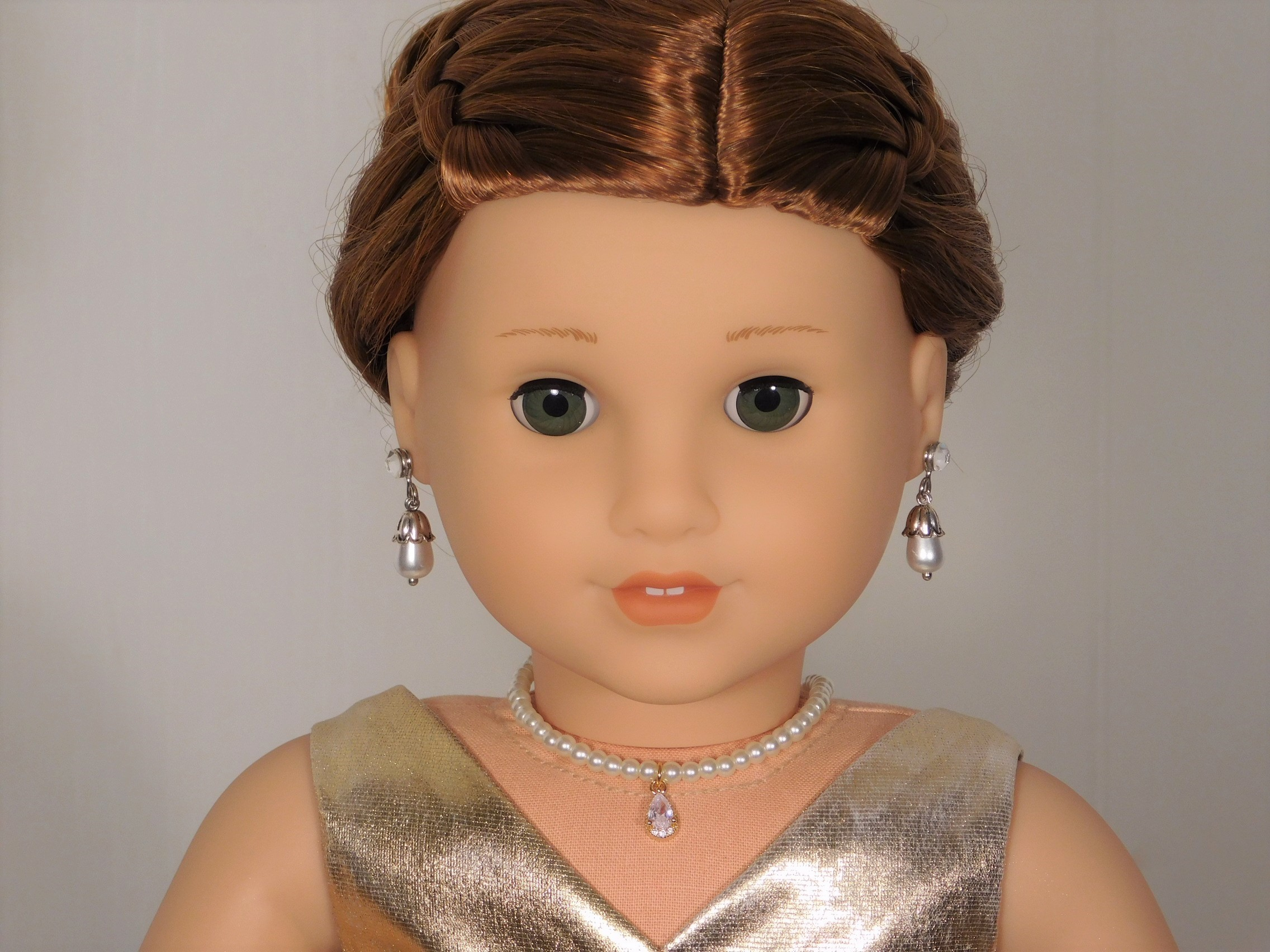 18 inch doll shown all dressed up wearing a string of white pearls with a sparkling clear center pendant
