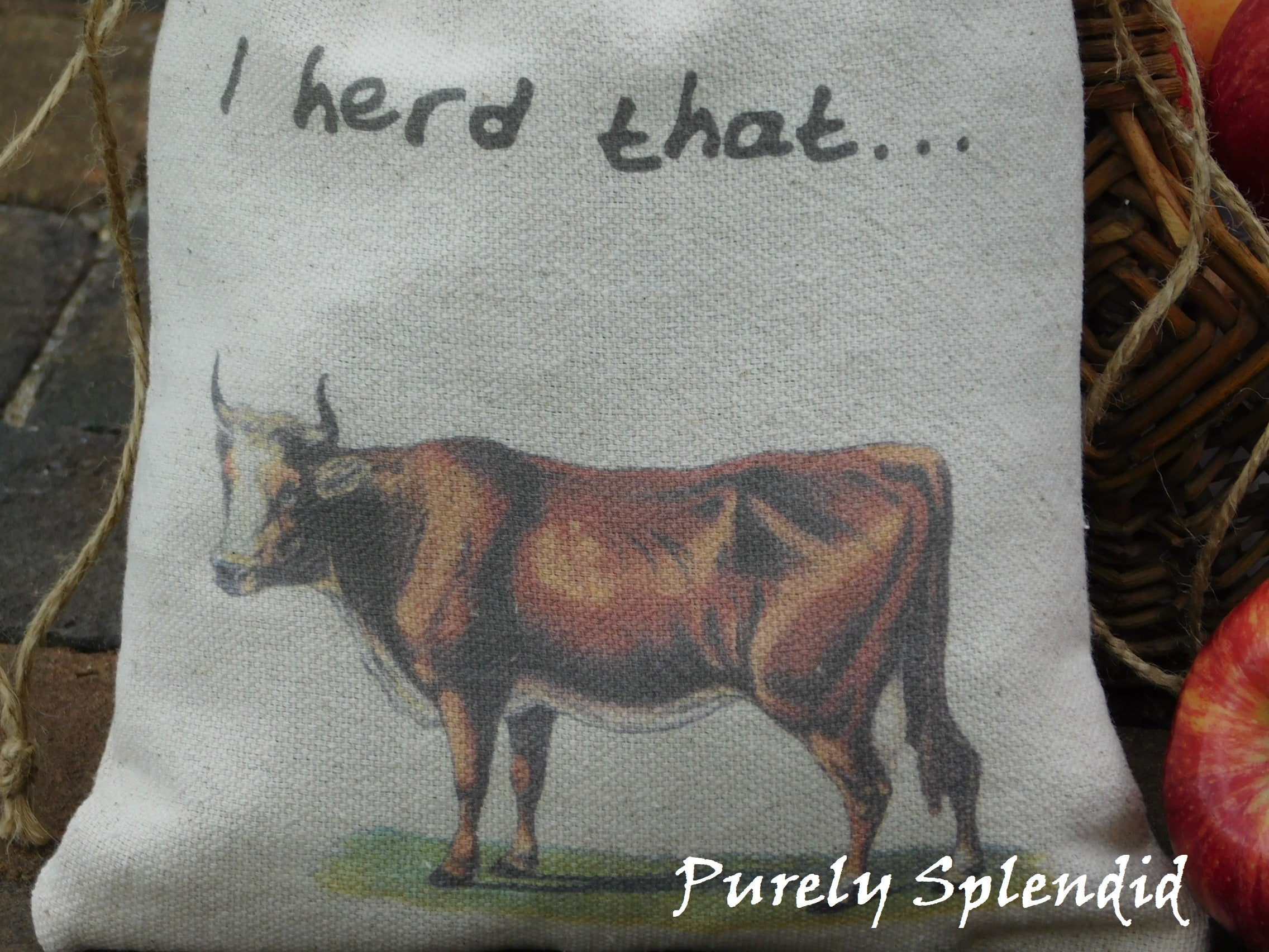 close up of a vintage brown cow image and the words I herd that printed on a fabric gift bag
