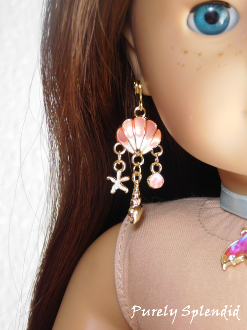 18 inch doll wearing a pair of pink Ariel Earrings with dangling shells and starfish 