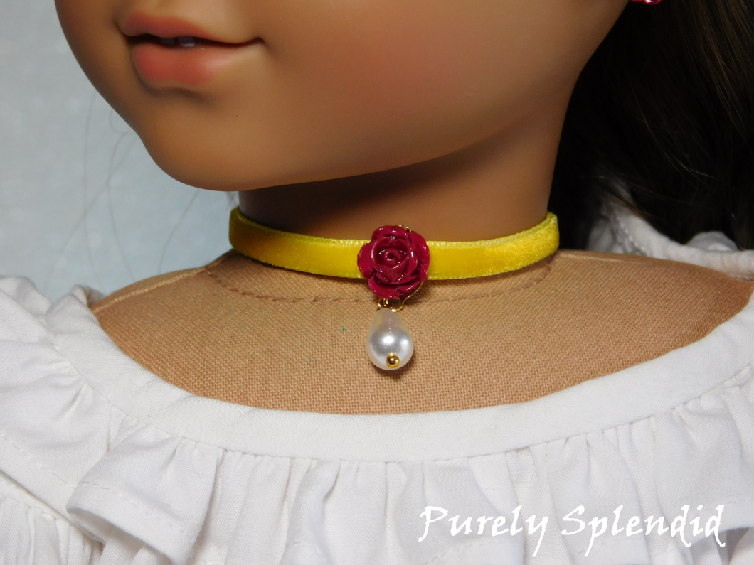 red rose flower with a white teardrop pearl hanging from it on a yellow velvet choker worn by an 18 inch doll