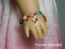 Load image into Gallery viewer, 18 inch doll shown wearing a Birthday Charm Bracelet with balloons and sparkling charms.
