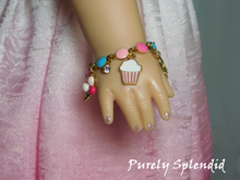 Load image into Gallery viewer, 18 inch doll shown wearing a festive Birthday Charm Bracelet shown with balloons, cupcake and sparkling charms
