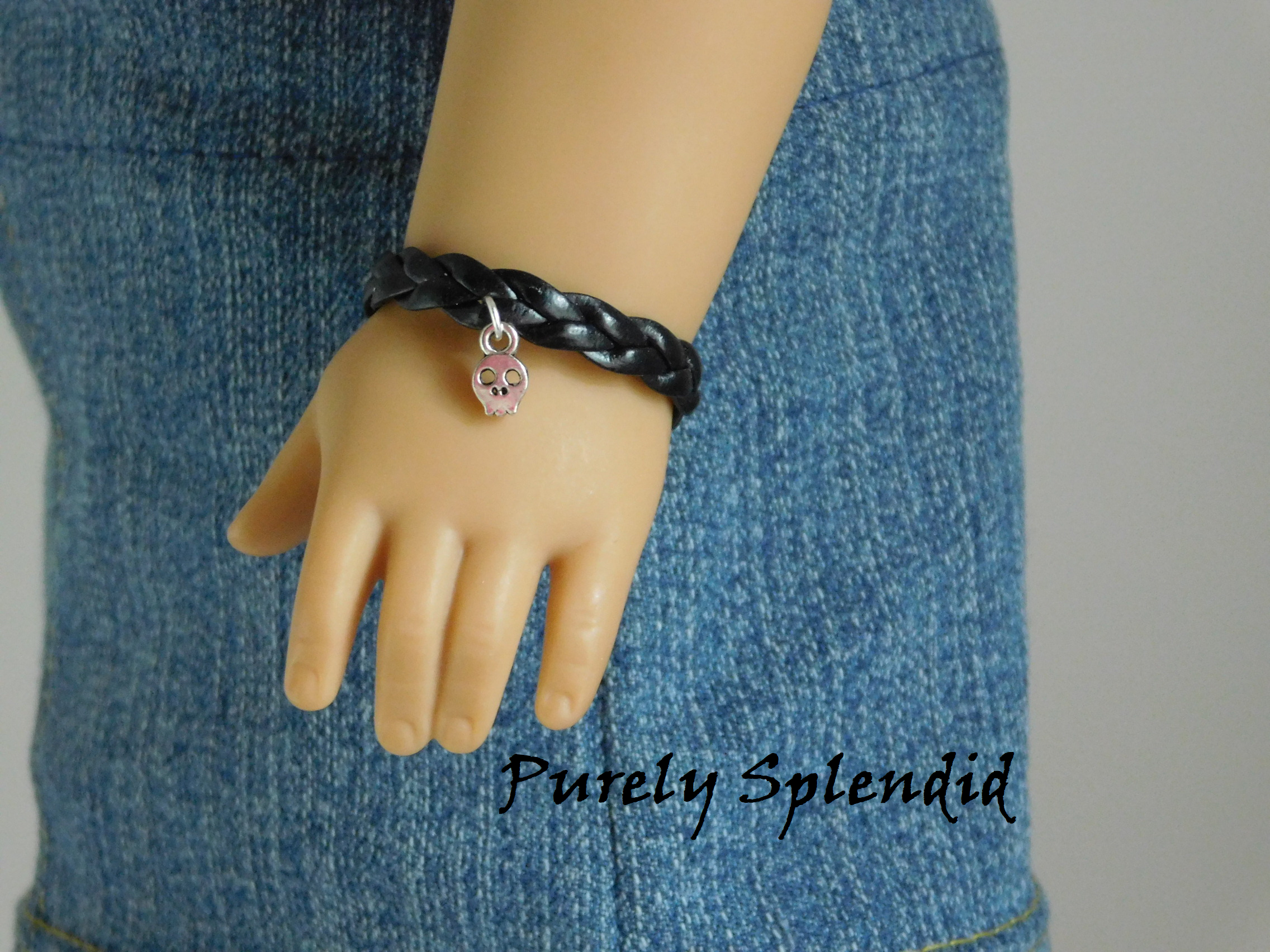 18 inch doll shown wearing a Black Braided Bracelet with Skull Charm