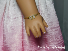 Load image into Gallery viewer, Sparkling Gold Bow Bracelet worn by an 18 inch doll
