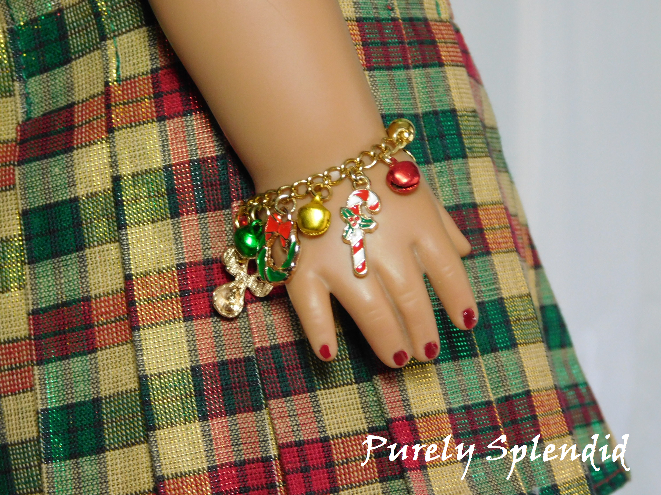 candy can and wreath charms along with festive colored bells on a gold chain worn by an 18 inch doll