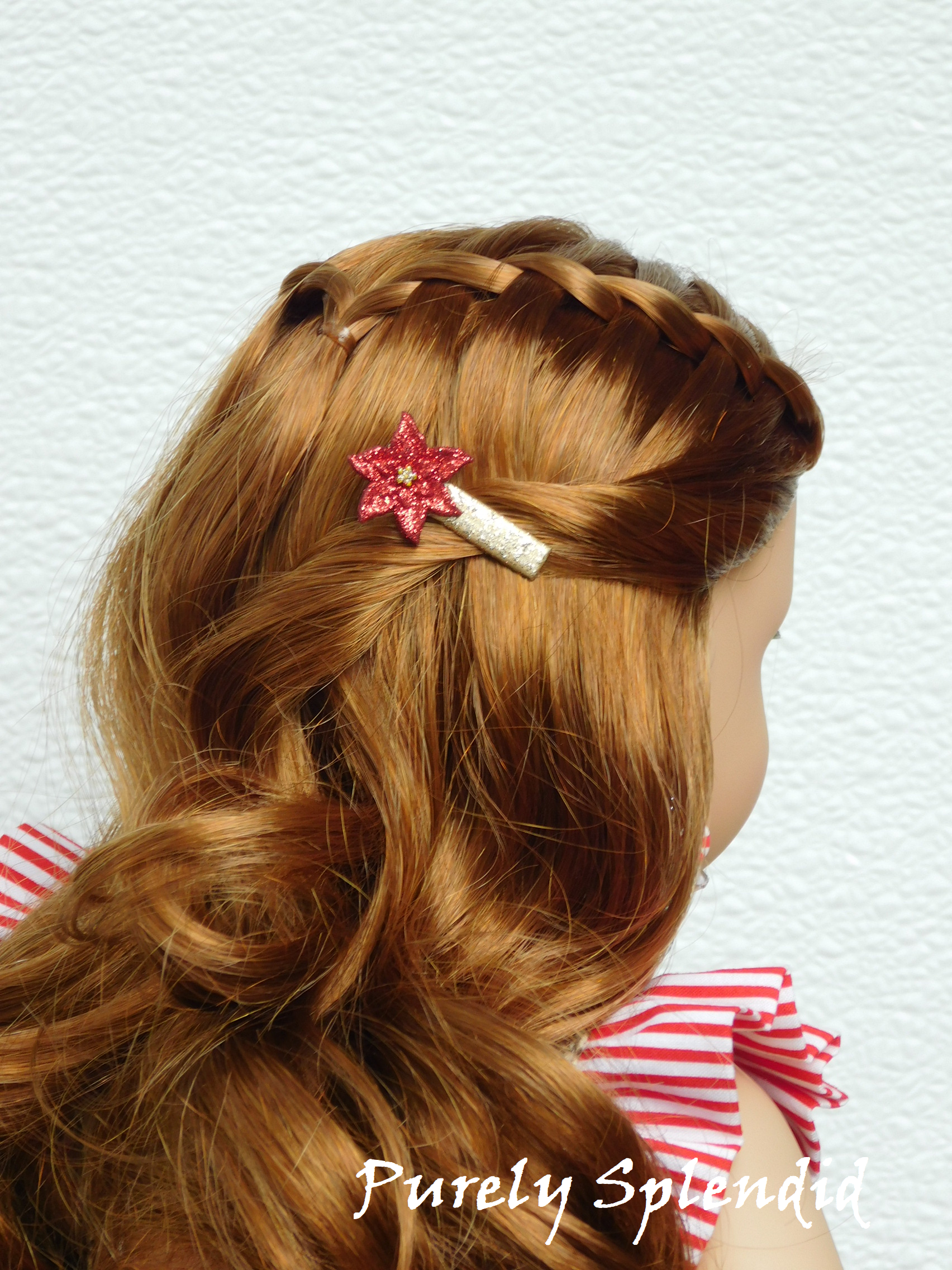 sparkling red poinsettia on a sparkling gold hair clip worn by an 18 inch doll