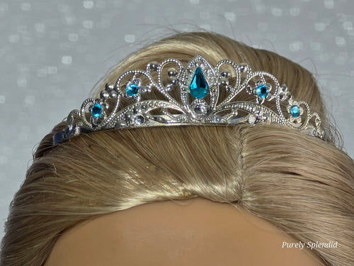 Silver filigree crown with sparkling blue accents worn by an 18 inch doll