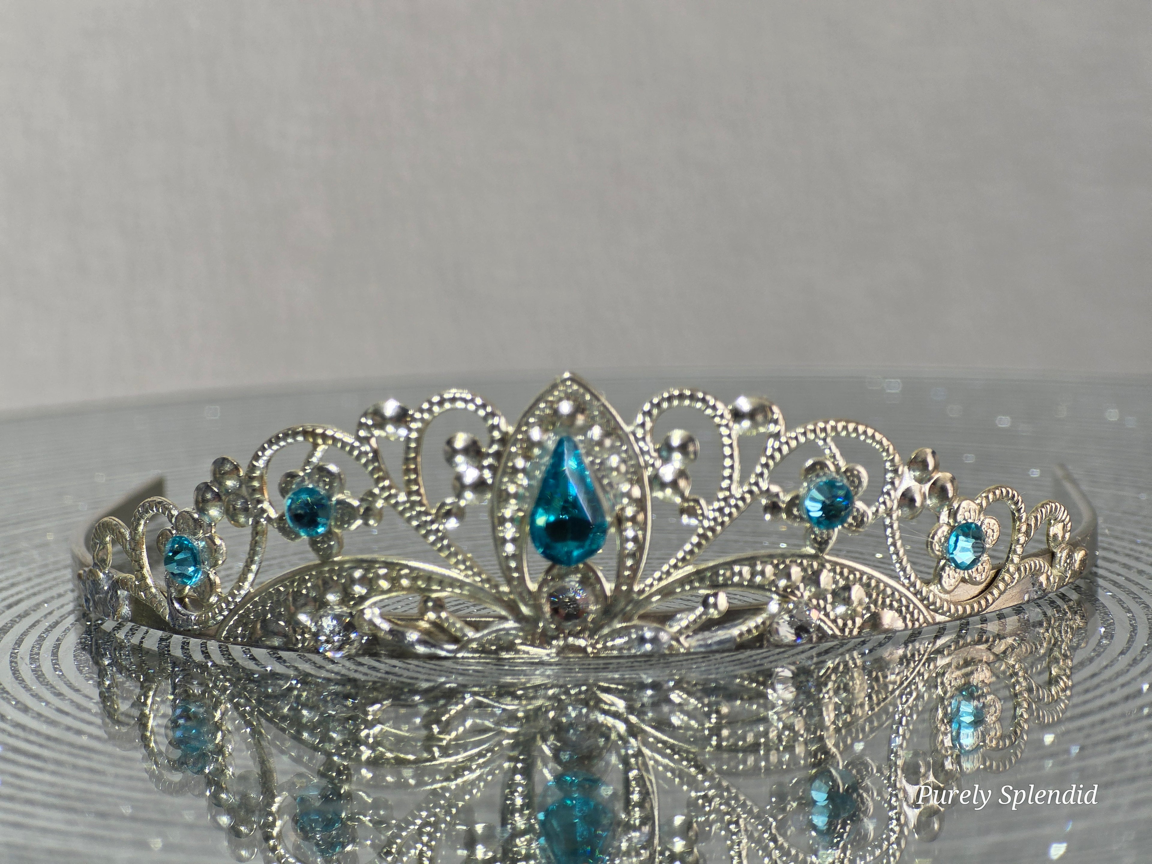 Silver filigree crown with sparkling blue accents