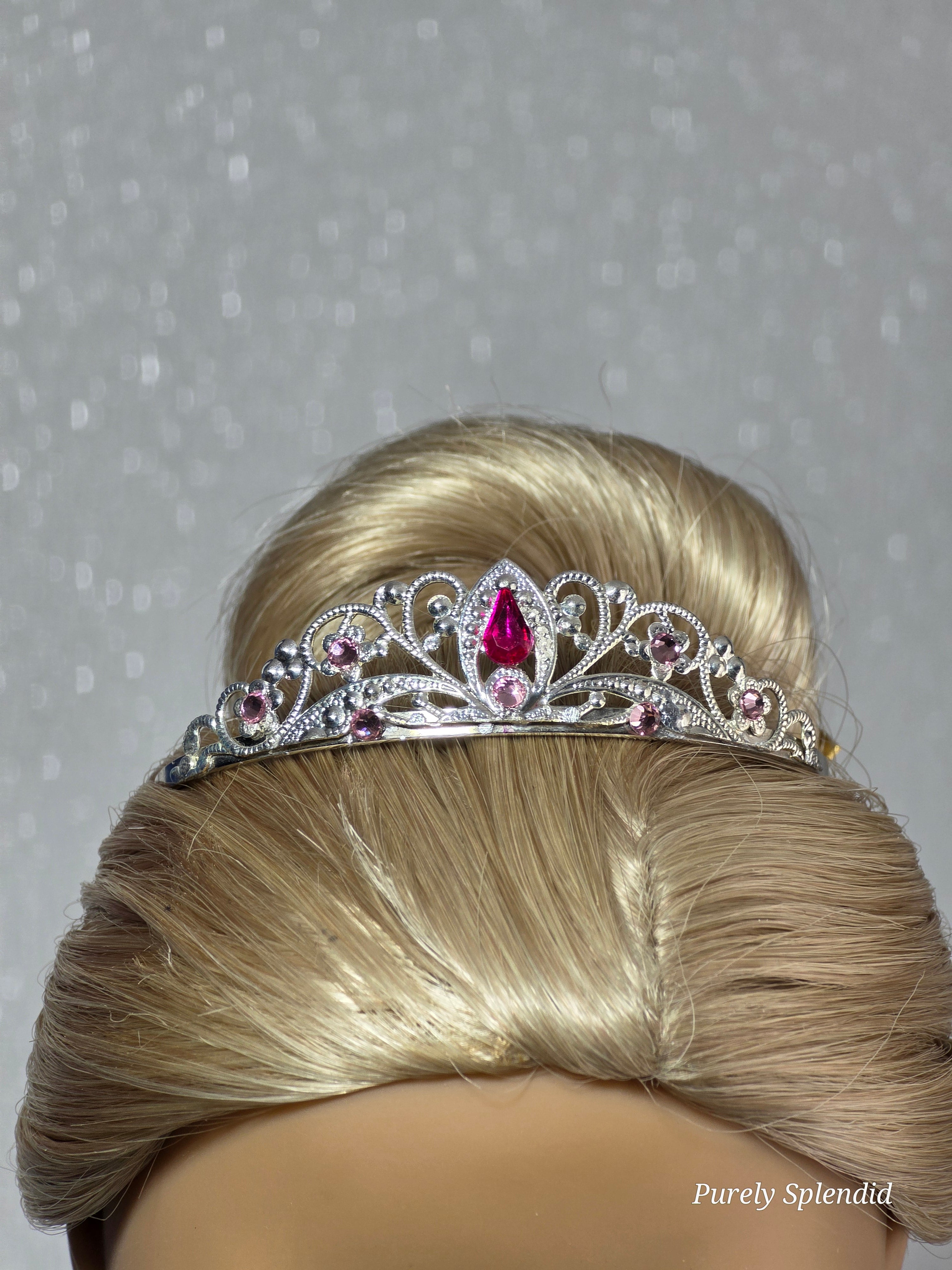 Silver filigree crown with sparkling pink crystals worn by an 18 inch doll