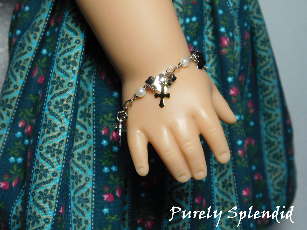 18 inch doll shown wearing a Cross Chrm Bracelet with tiny hearts and gold and silver colored crosses