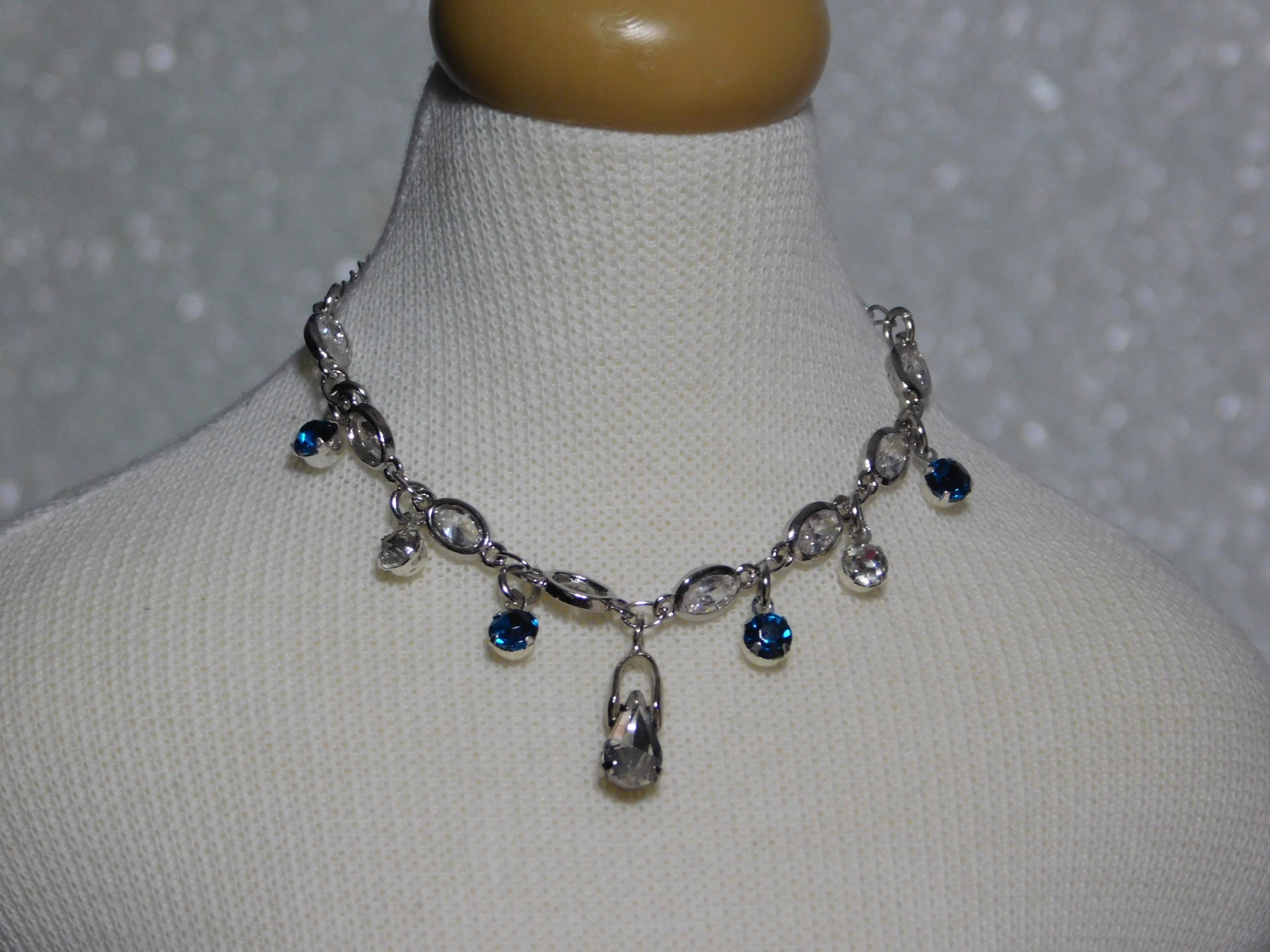 crystal necklace with four azure blue dangles and two crystal dangles and a large teardrop crystal center dangle