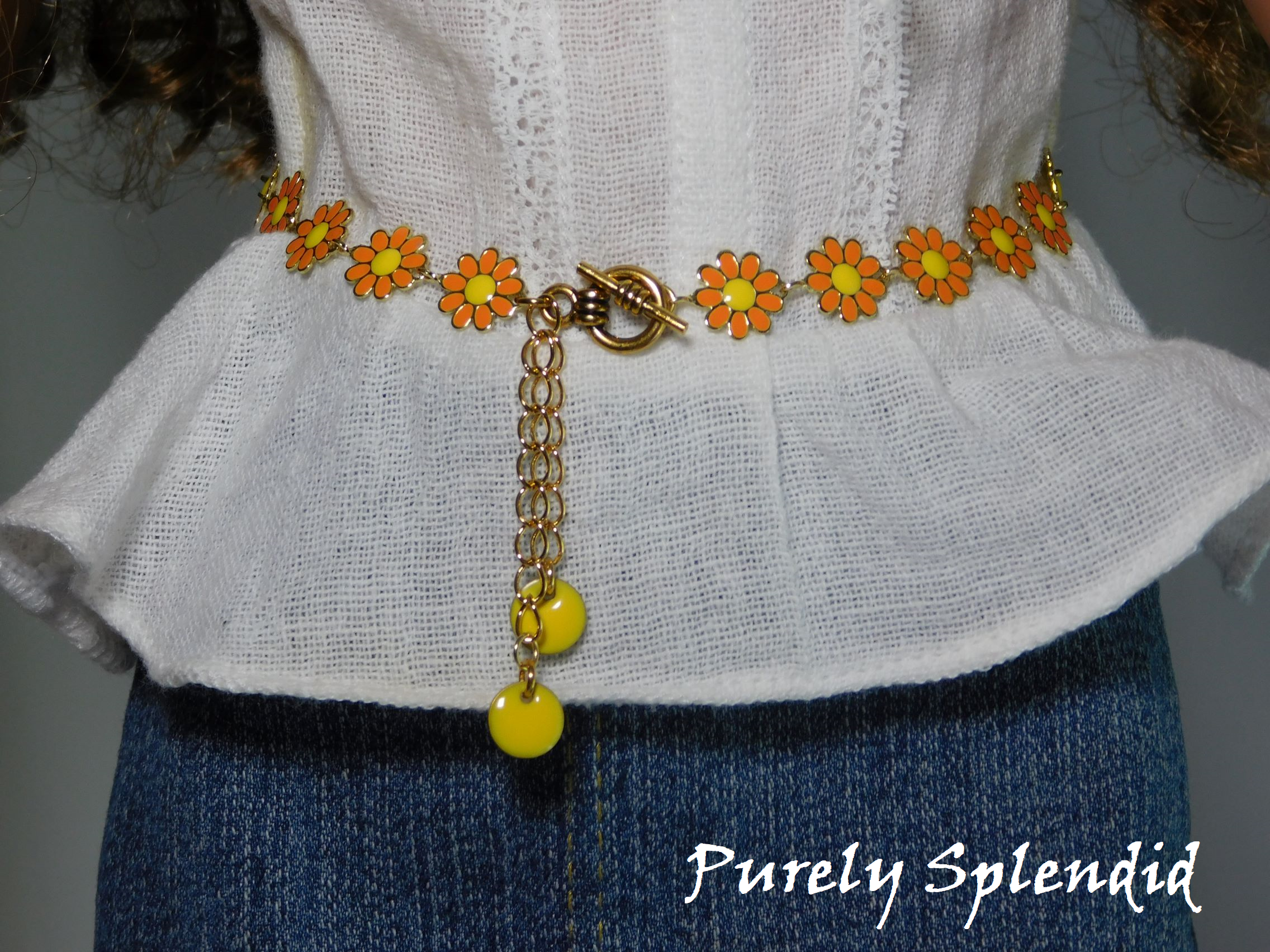 18 inch doll shown wearing an Orange Daisy Belt with yellow dangles