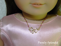 18 inch doll wearing a sparkling gold dog charm necklace with unique pink and gold chain