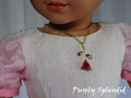 red rose tipped in gold on a gold chain worn by an 18 inch doll