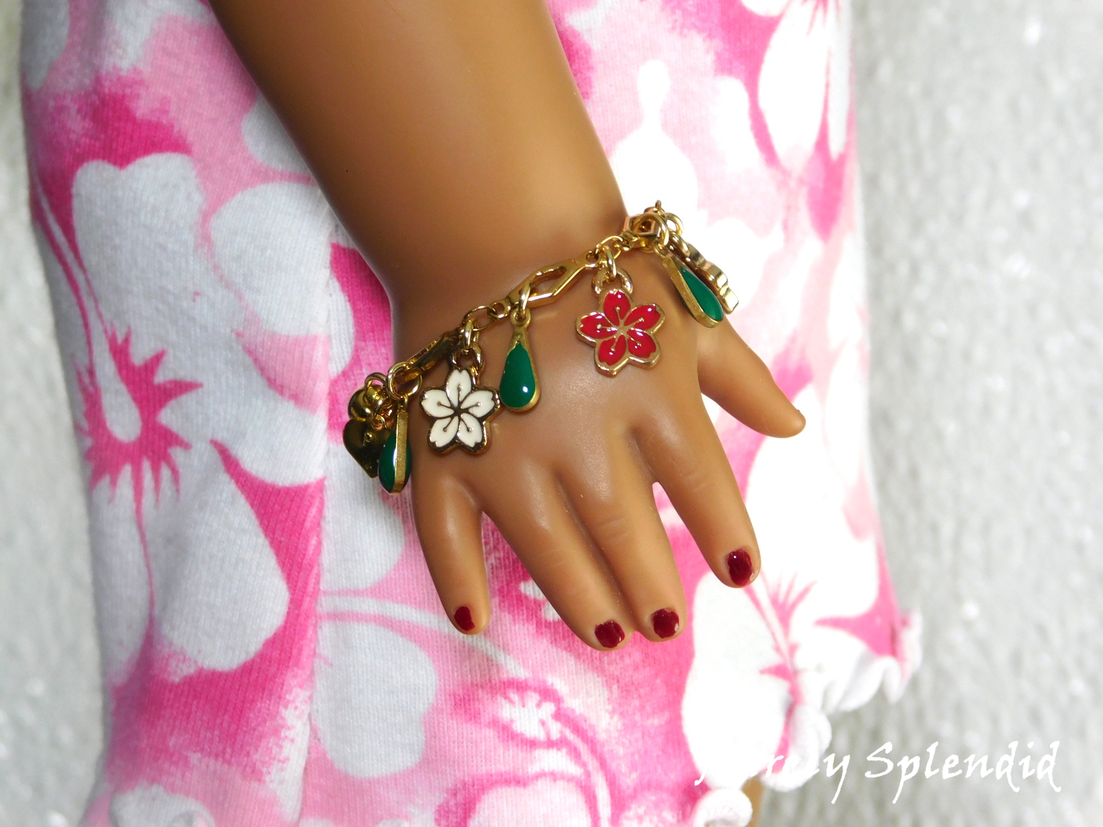 18 inch doll wearing a Flower Lei Bracelet with red, pink and white Hibiscus flowers and green dangles
