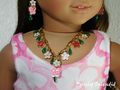 18 inch doll wearing a colorful flower lei necklace with white, pink and red Hibiscus flowers and green dangles