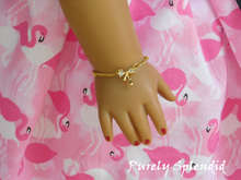 Load image into Gallery viewer, Cubic Zirconia Gold Bow on a simple gold chain shown on an 18 inch doll
