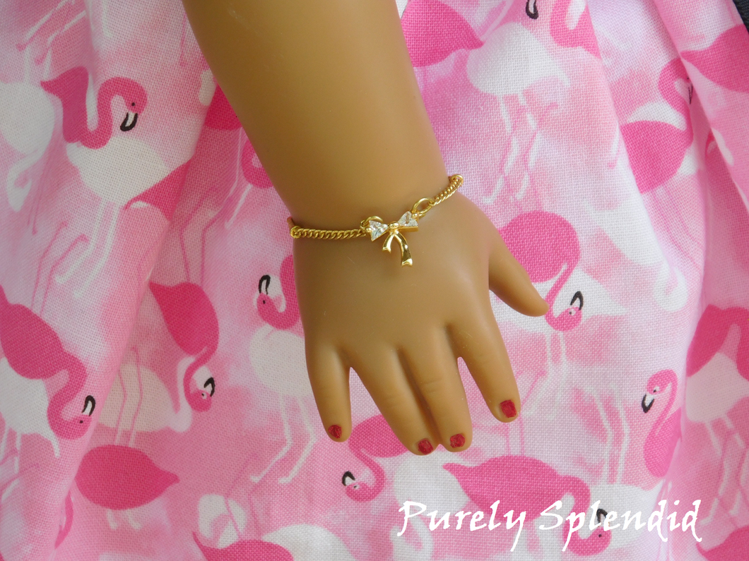 Cubic Zirconia Gold Bow on a simple gold chain shown on an 18 inch doll