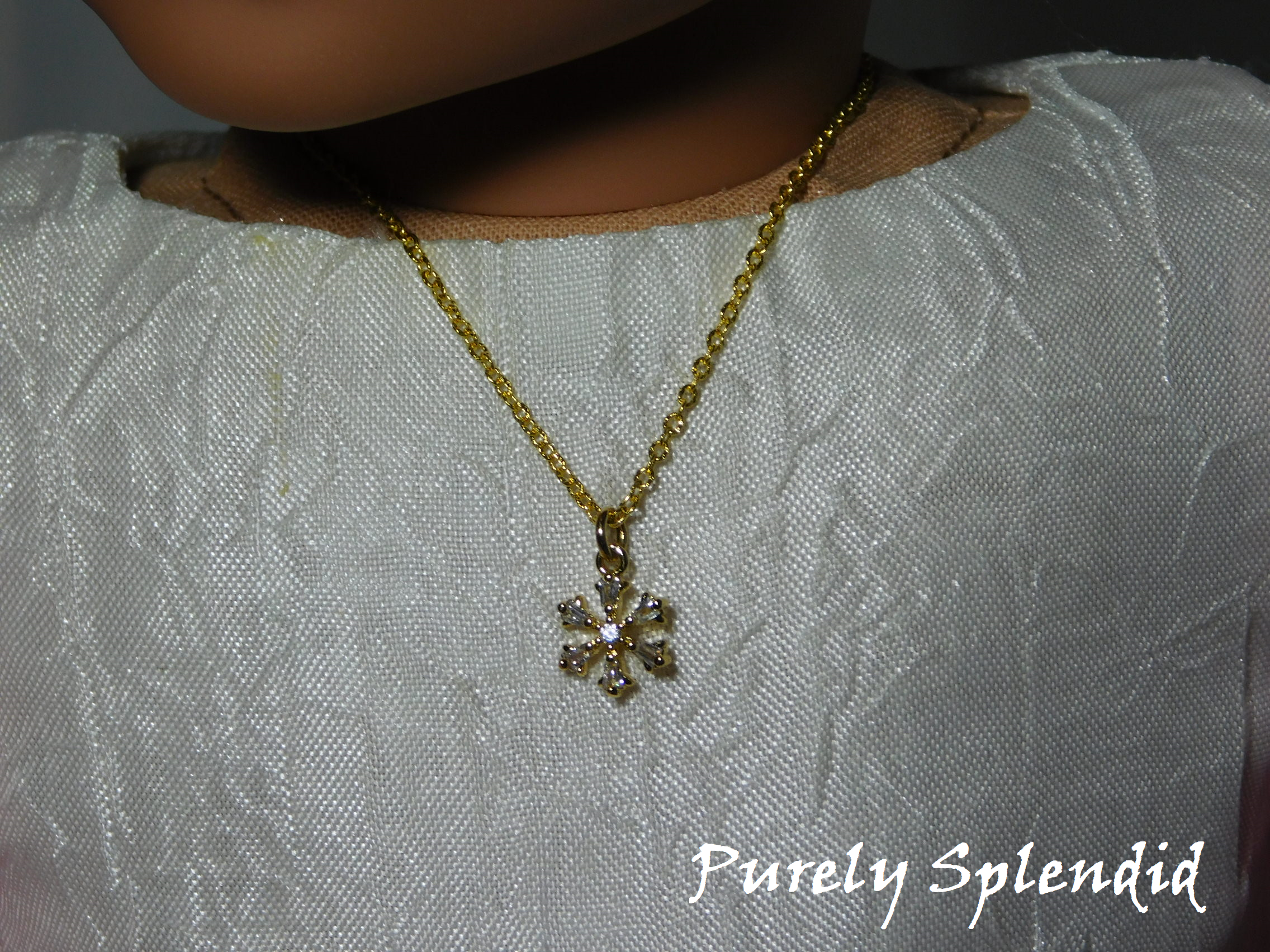 18 inch doll wearing a gold snowflake necklace