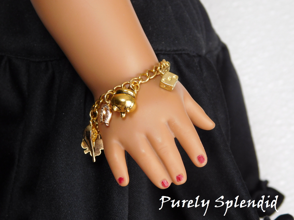 gold charms on a gold bracelet - shamrock, genie lamp, horse shoe, pot of gold and die