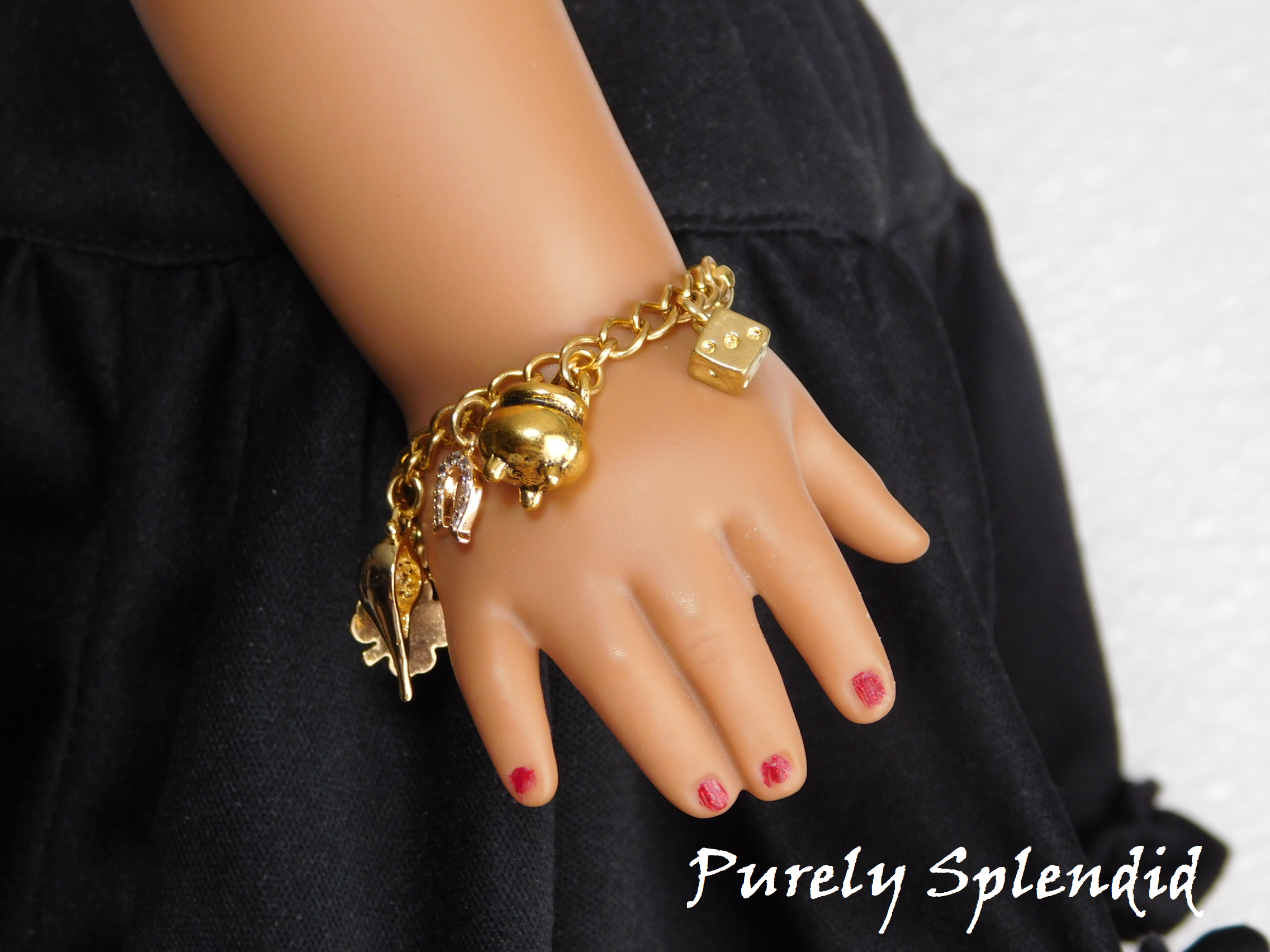 gold charms on a gold bracelet - shamrock, genie lamp, horse shoe, pot of gold and die