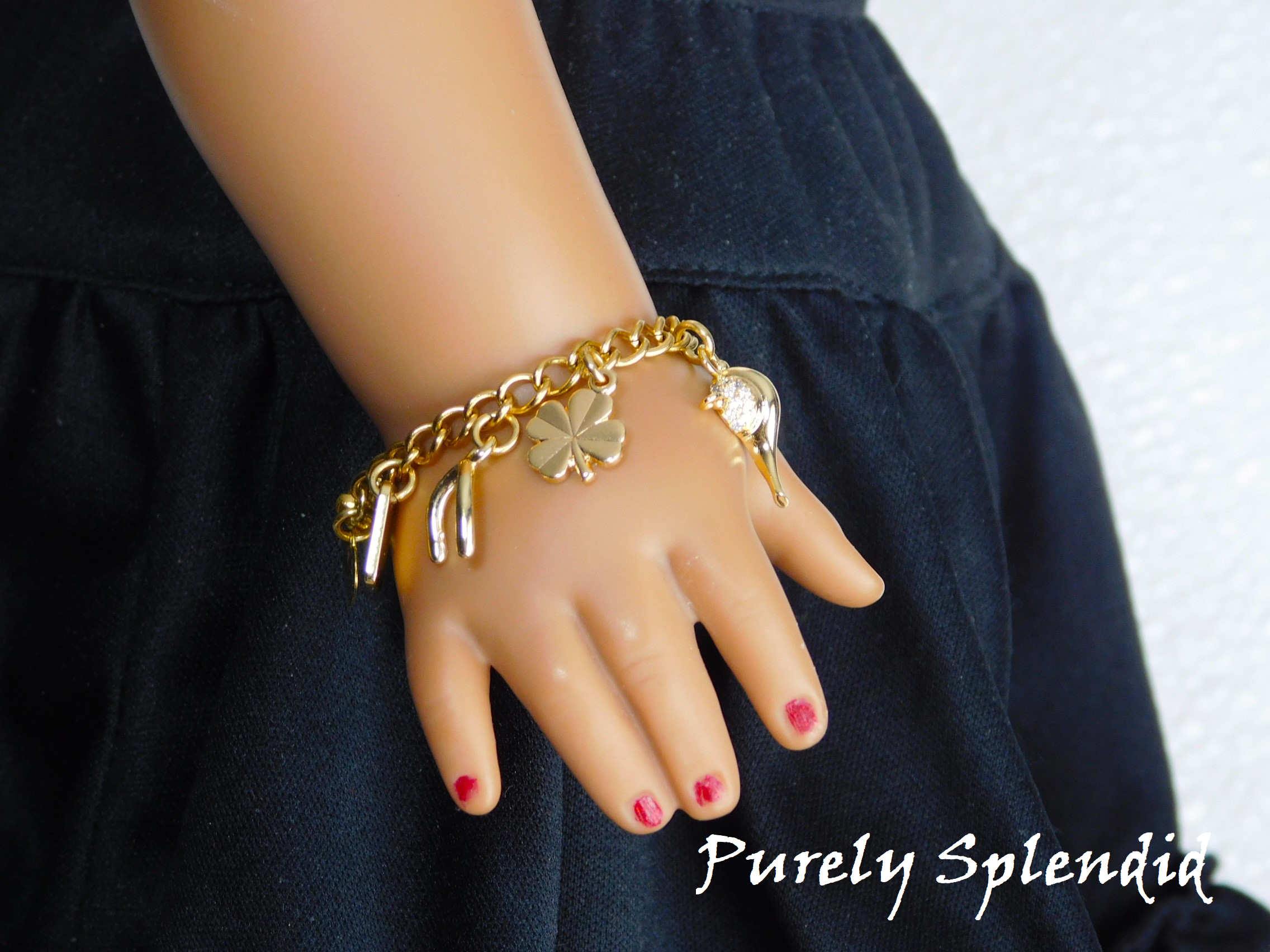 gold charms on a gold bracelet worn by an 18 inch doll