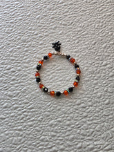Load image into Gallery viewer, Orange and Black Sparkling Halloween Bracelet with lack skull and crossbones charm
