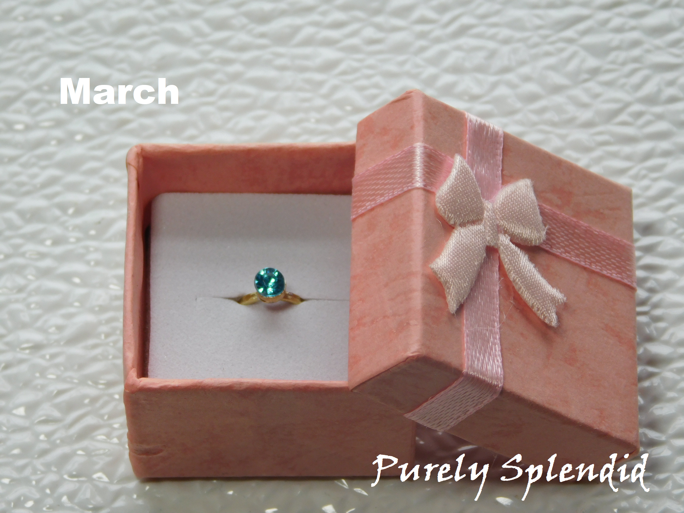 sparking light blue center crystal on a gold band