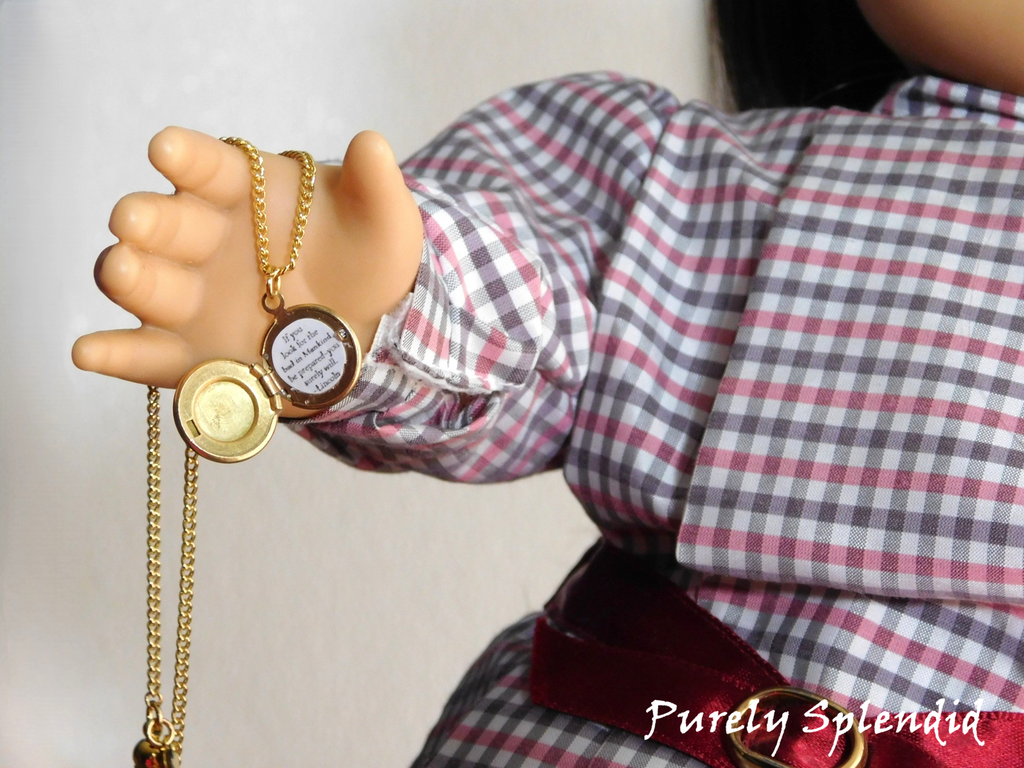 Round locket with Pollyanna saying inside held by an 18 inch doll