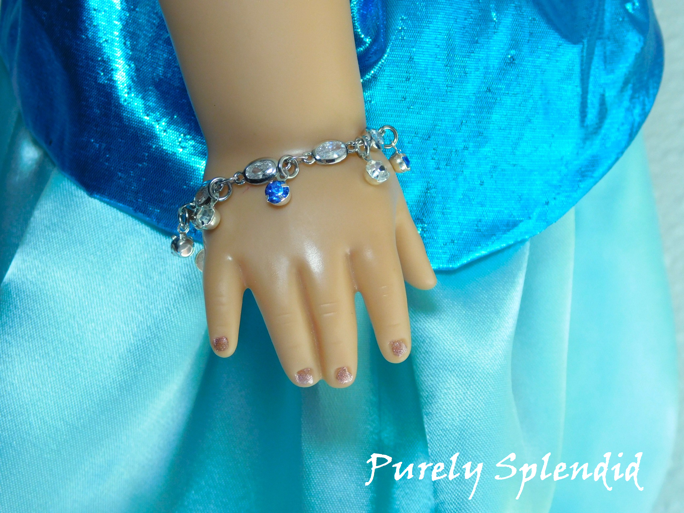 crystal bracelet with alternating light blue and clear crystal dangles shown worn by an 18 inch doll