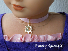 Load image into Gallery viewer, 18 inch doll shown wearing Rapunzel Choker Necklace featuring an 18KG plated sun with an large sparkling Aurora Borealis center crystal on a pink satin ribbon
