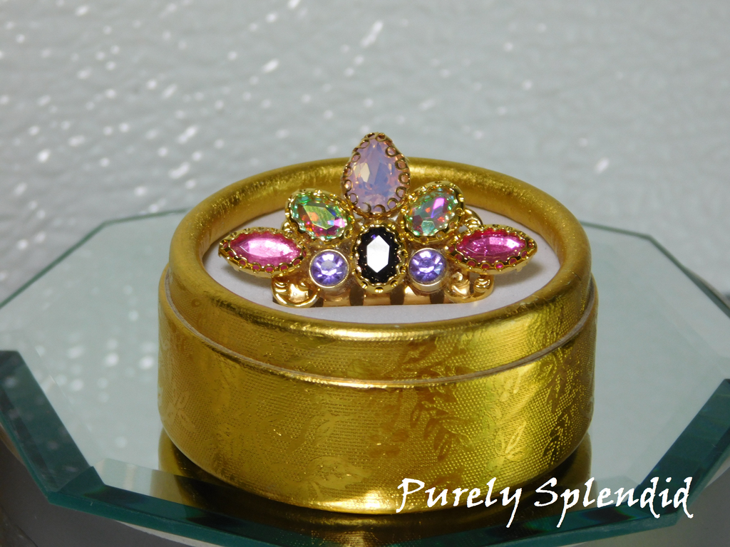 beautiful jeweled mini crown with pink, purple, opal and aurora borealis stones. shown in a gold gift box