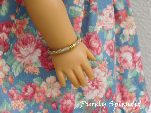 18 inch doll shown wearing a Faux Snakeskin Bracelet in a light beige color with three gold rings in the middle