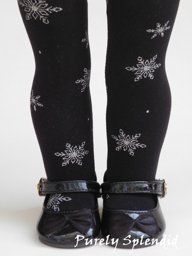 Sparkling silver snowflakes on black tights shown on an 18 inch doll