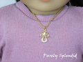 18 inch doll wearing a sparkling gold angel on a gold chain
