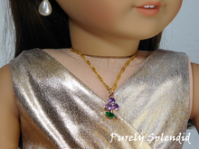 Load image into Gallery viewer, 18 inch doll shown wearing a Sparkling Purple Flower Necklace. Flower charm has 3 sparkling purple petals and a sparkling green leaf hanging from a pretty twisted gold chain.
