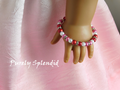 pink, white and red pearls with silver sparkles in this bracelet worn by an 18 inch doll
