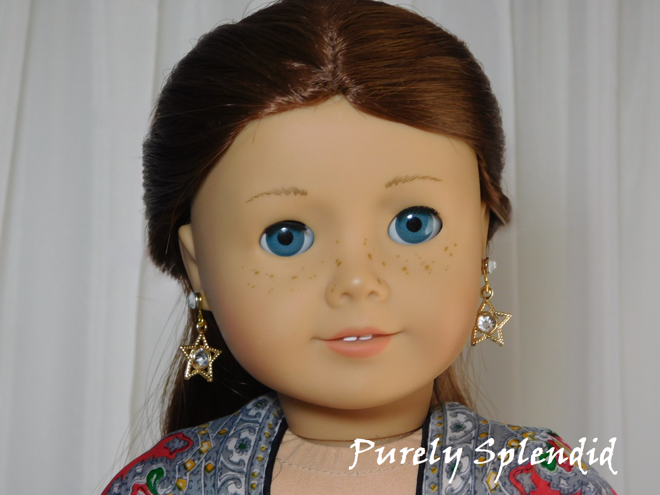 18 inch doll shown wearing a pair of Sparkling Gold Star Earrings - gold open stars with a large sparkling center stone