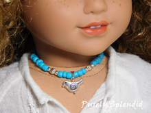 Load image into Gallery viewer, 18 inch doll shown wearing a blue and silver beaded necklace with a silver bird pendant
