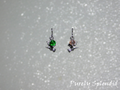 flying witch earrings with sparkling crystal dangles one earring has a pink crystal and the other has a green crystal
