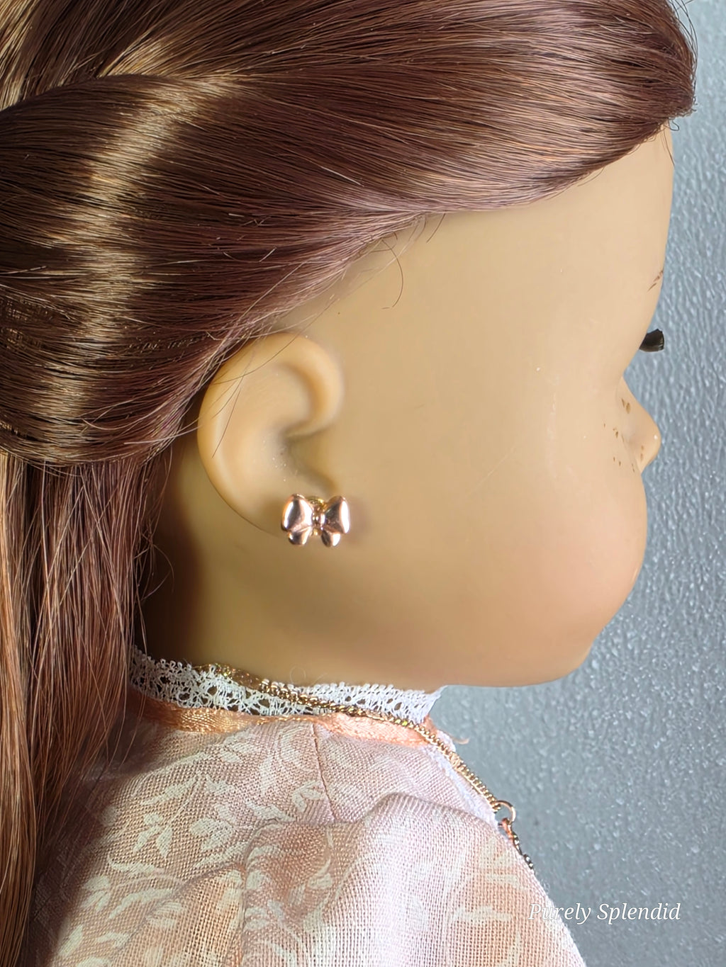 Rose gold bow stud earrings worn by 18 inch girl doll