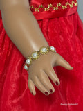 Flat gold flowers with pearl centers make up this bracelet worn by an 18 inch doll