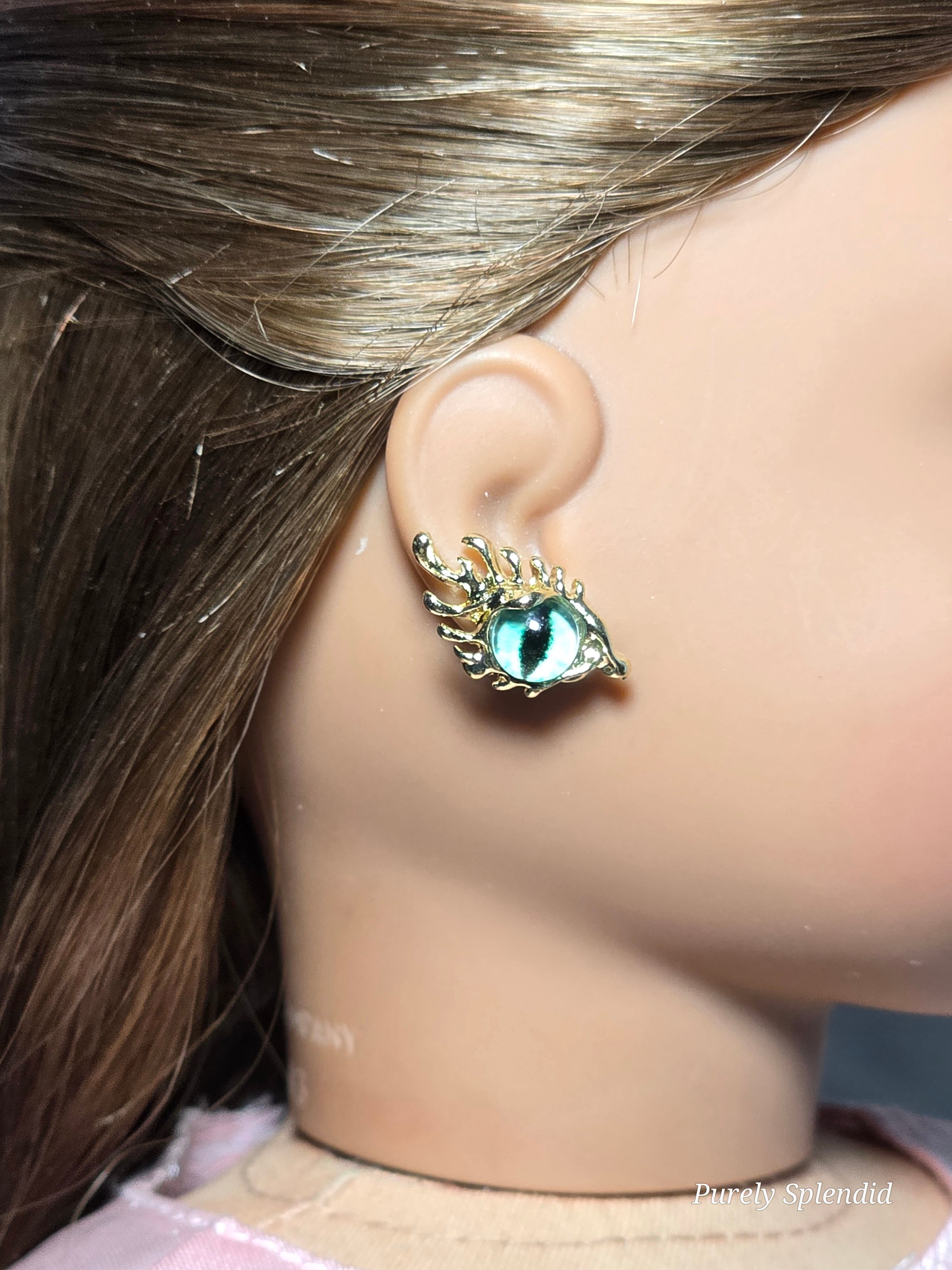 18 inch doll wearing a pair of green eye studs with fancy lashes