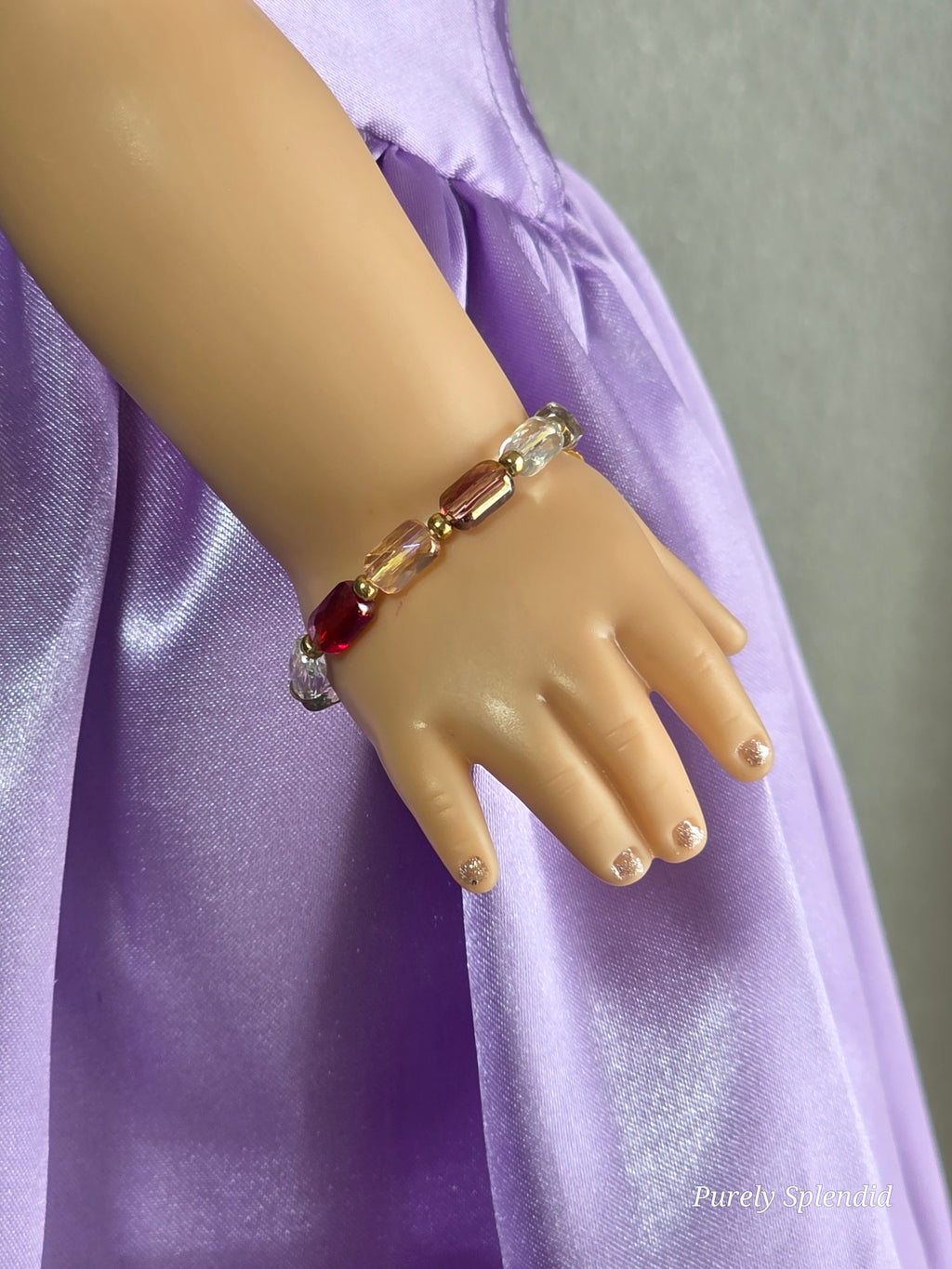 18 inch doll wearing multi-colored crystal bracelet