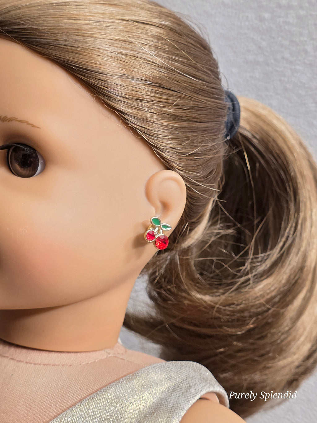 18 inch girl doll wearing a pair of Sparkling Cherry Studs for dolls who have 2mm holes / American made / Purely Splendid